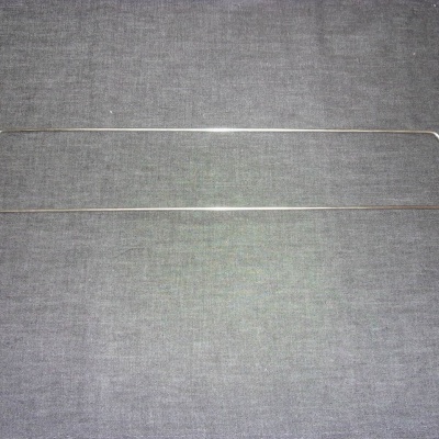 Cabos metálicos finos com pontas curvas e revestidas a preto sobre tecido cinza