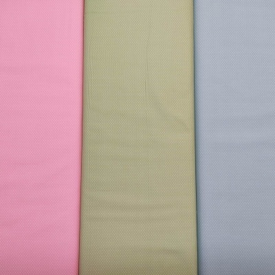 Três tecidos coloridos com padrão de pequenos pontos lado a lado.