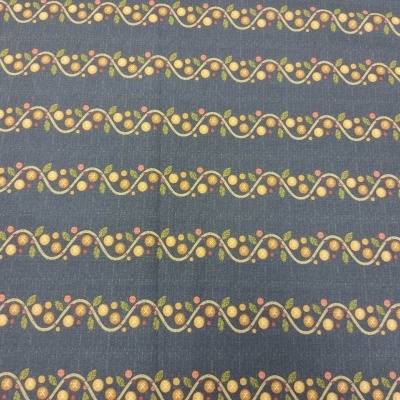 Tecido cinza escuro com padrão de linhas onduladas amarelas e laranja com pequenos círculos coloridos.