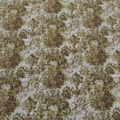 Tecido floral verde, dourado e bege sobre superfície de madeira clara