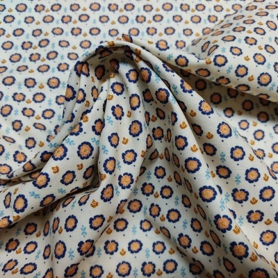 Tecido de algodão com padrão floral azul e castanho sobre fundo bege