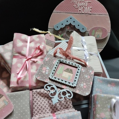 Tecidos coloridos com fitas e placas decorativas com texto e imagens de casas