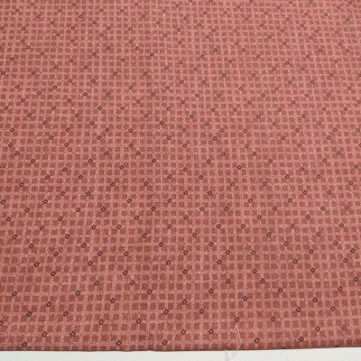 Tecido vermelho escuro com padrão de cruzes e pontos pretos