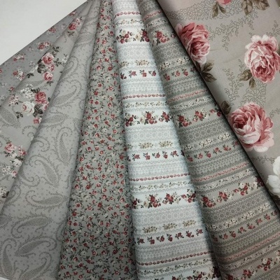 Conjunto de tecidos decorativos com padrões florais e riscas em tons neutros