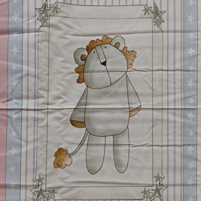 Colcha infantil com desenho de leão cinza e amarelo e bordas de estrelas brancas sobre fundo azul e riscas azuis e brancas