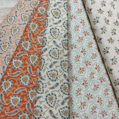 Tecidos florais dobrados variados sobre madeira clara