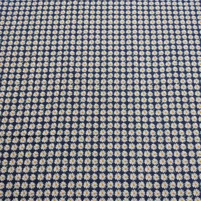 Tecido azul escuro com padrão de margaridas brancas pequenas e amarelas.