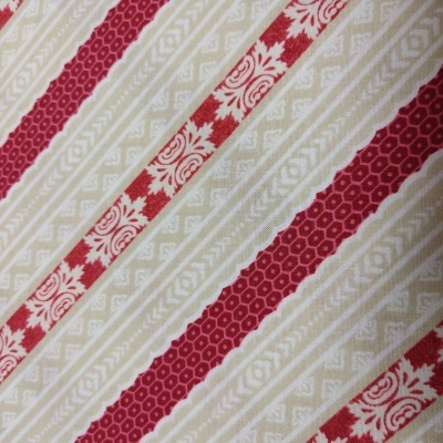 Pano com padrão de riscas diagonais vermelhas e bege com motivos geométricos e florais