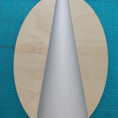 Cone branco de isopor sobre madeira clara numa mesa azul quadriculada