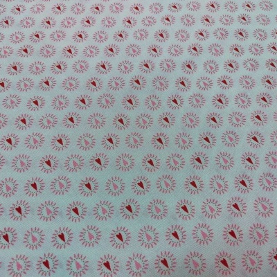 Papel ou tecido branco com padrão repetitivo de círculos vermelhos em forma de flor.