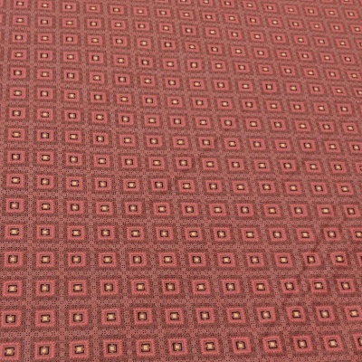 Tecido com padrão geométrico de pequenos quadrados em vermelho e castanho