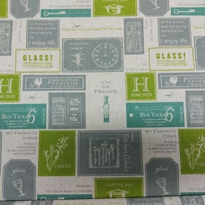 Tecido estampado com texto em inglês e desenhos em tons de verde, cinza e bege.