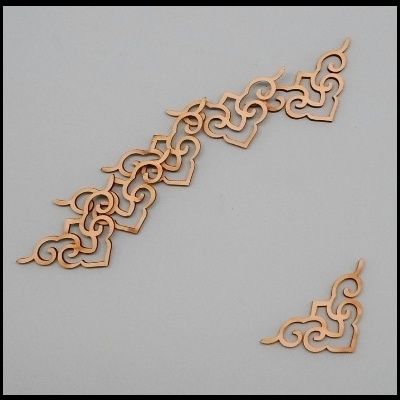 Peças decorativas de madeira clara com padrões caligráficos sobre fundo cinza