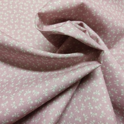 Tecido rosa com pequenas flores brancas uniformemente distribuídas