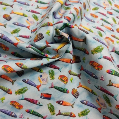 Tecido azul claro com padrão colorido de peixes e latas