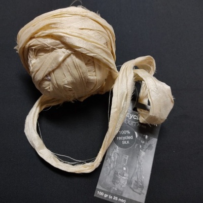 Rolo de fita em tecido creme com etiqueta preta e texto 100% recycled SILK