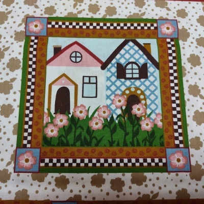 Tecido estampado com casas, flores e padrão quadriculado