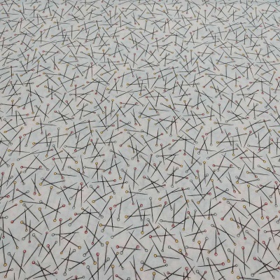 Tecido branco com padrão de alfinetes coloridos e linhas pretas