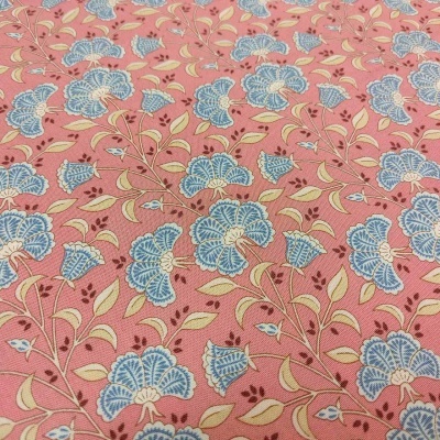 Tecido rosa com flores azuis e detalhes em bege.