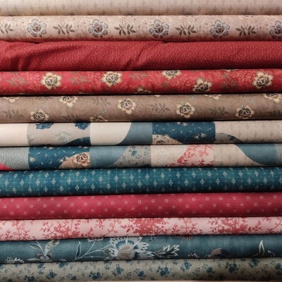 Tecidos dobrados com padrões florais em vermelho, azul, bege e rosa