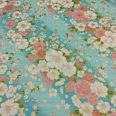 Tecido azul com flores brancas, rosas e detalhes dourados.