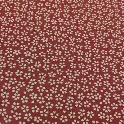Tecido vermelho com padrão repetido de pequenas flores brancas