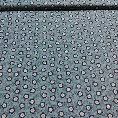 Rolo de tecido com padrão floral azul esverdeado sobre superfície plana