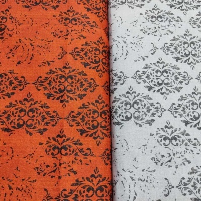 Tecidos estampados laranja e branco com padrão floral barroco preto e cinzento