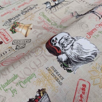 Tecido com estampado natalício de Papai Noel, sinos, trenó e textos em várias cores.