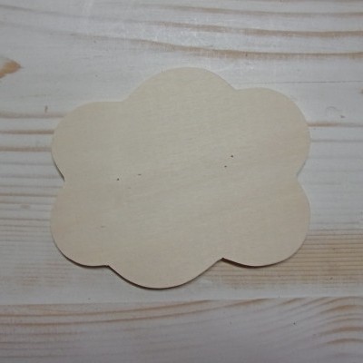 Placa de madeira em formato de nuvem sobre superfície de madeira clara