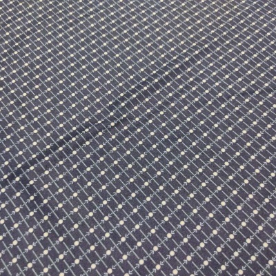 Tecido azul escuro com padrão de linhas e pontos brancos em losangos