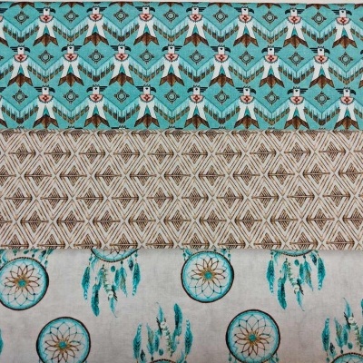 Três tecidos com padrões de raposas, padrão geométrico e círculos com penas em tons de azul, castanho e bege.