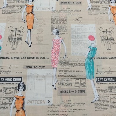 Tecido estampado com desenhos de mulheres em vestidos e textos de guia de costura em fundo bege.