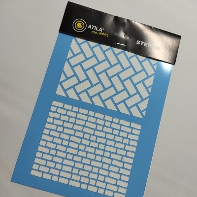 Stencil plástico azul com padrões de tijolos embalado em suporte preto
