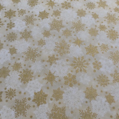 tecido bege com flocos de neve dourados e brancos