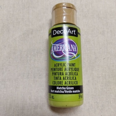 Frasco de tinta acrílica DecoArt Americana verde Matcha sobre superfície bege