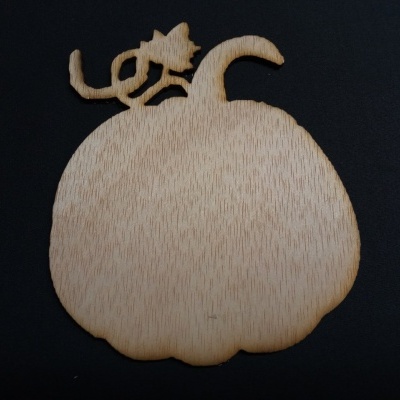 Prato decorativo em madeira em forma de abóbora com um gato no topo, sobre fundo preto