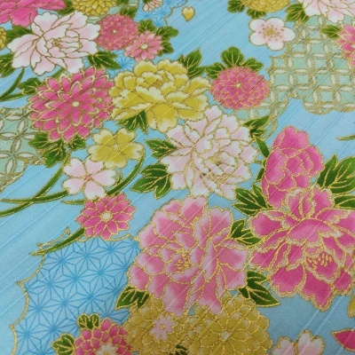 tecido azul com padrão floral em rosa, amarelo e verde, detalhes dourados