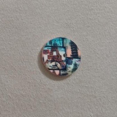 Botão redondo colorido com padrão abstrato sobre tecido cinza claro