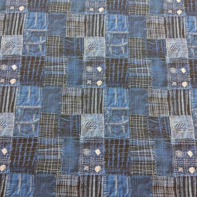 Tecido patchwork azul e preto com padrões xadrez e detalhes em branco