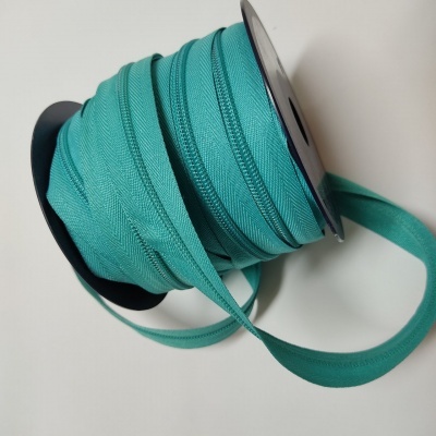 Rolo de fita de tecido verde-azulado com bordas costuradas
