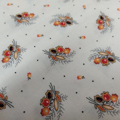 Tecido branco com padrão floral em vermelhos, laranjas e preto.