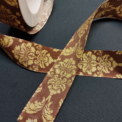 Faixa decorativa com padrão dourado sobre fundo castanho