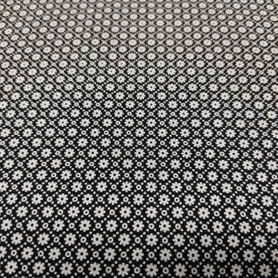 Tecido preto com padrão repetido de flores brancas pequenas