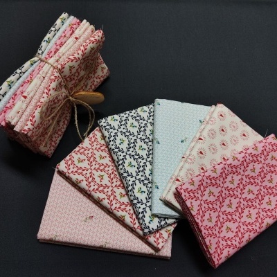 Conjunto de tecidos estampados com padrões florais e geométricos em tons de rosa, branco e azul claro