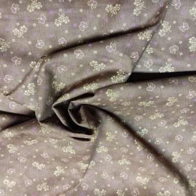 Tecido castanho com flores lilás, branco e bege pequenas