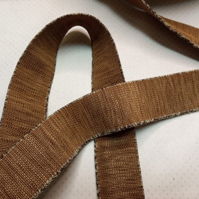 Fita de tecido castanha com bordas brancas sob fundo branco