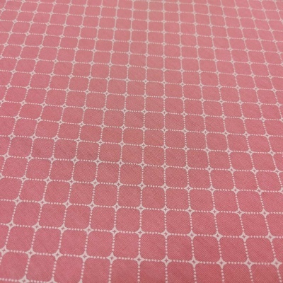 Tecido cor-de-rosa com padrão de quadrados brancos pontilhados.