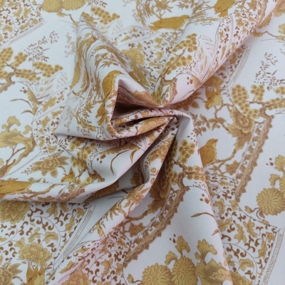 Tecido branco com padrão floral dourado e amarelo com textura franzida