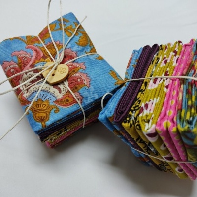 Dois conjuntos de tecidos coloridos dobrados e amarrados com fio